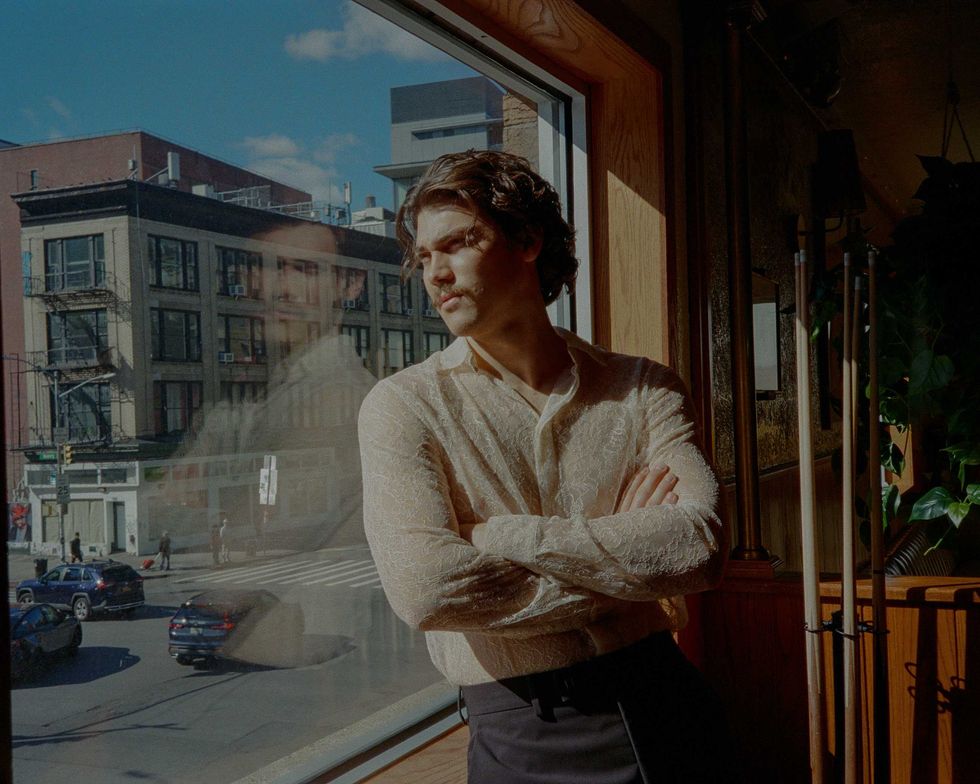Jack Inannen standing near a window in a New York City Bar.