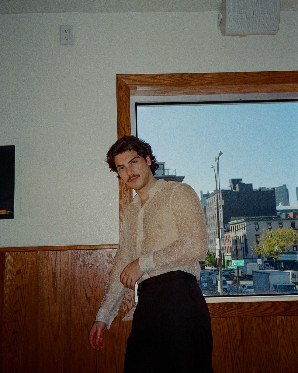 Jack Inannen standing near a window in a New York City Bar.