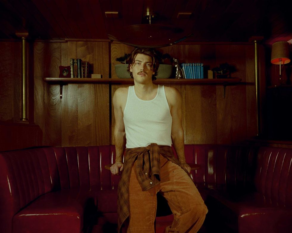 Jack Innanen in a white tank top and pants.