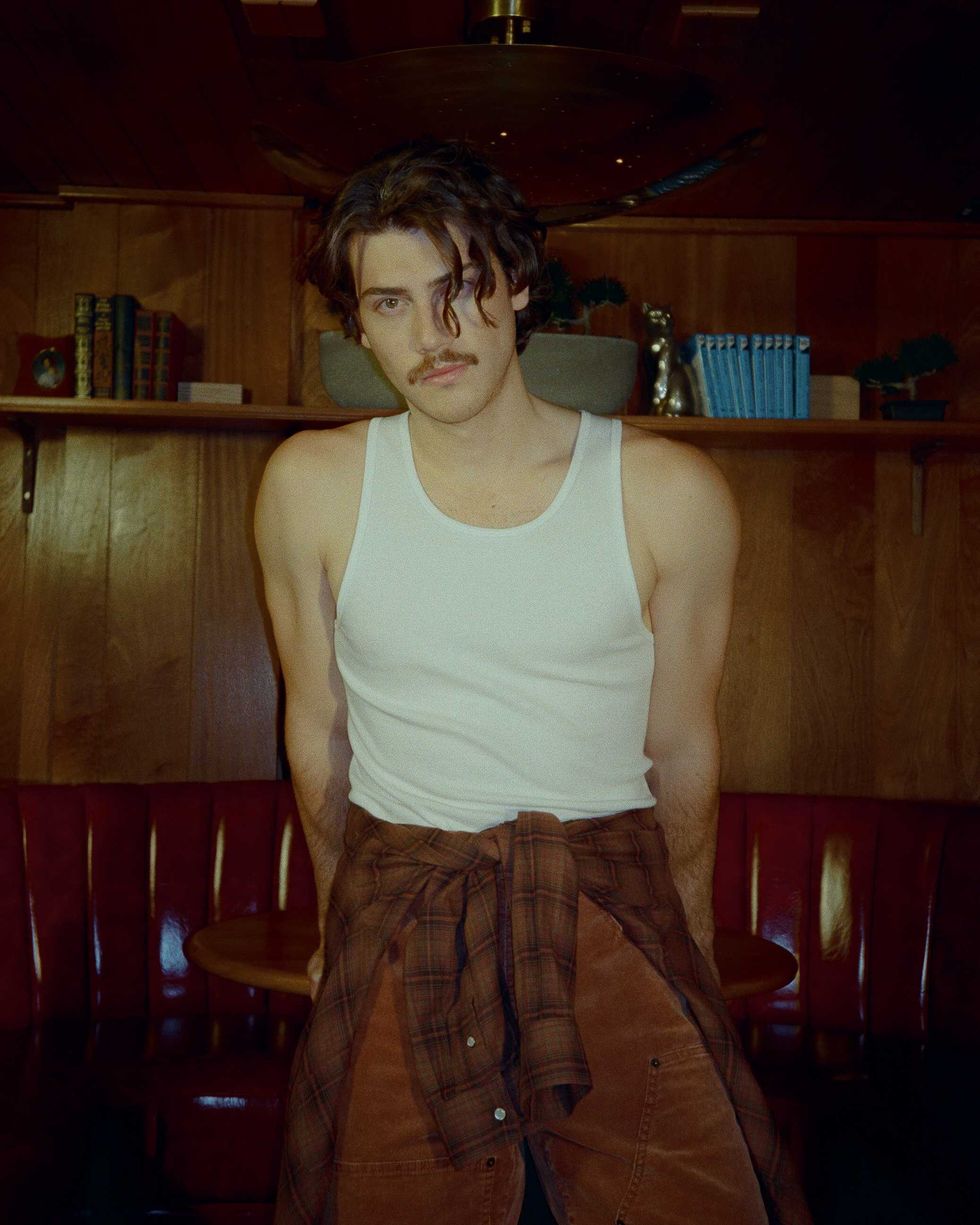 Jack Innanen in a white tank top and pants.