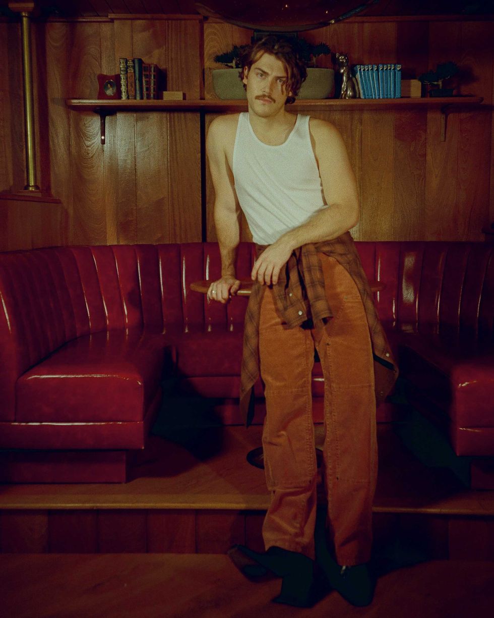 Jack Innanen in a white tank top and pants.